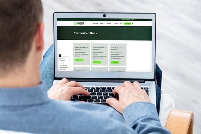 A man reviewing the Insider Trading Alerts website on a laptop.